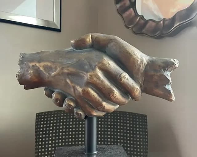 Bronze handshake sculpture inside the Auto Gals dealership
